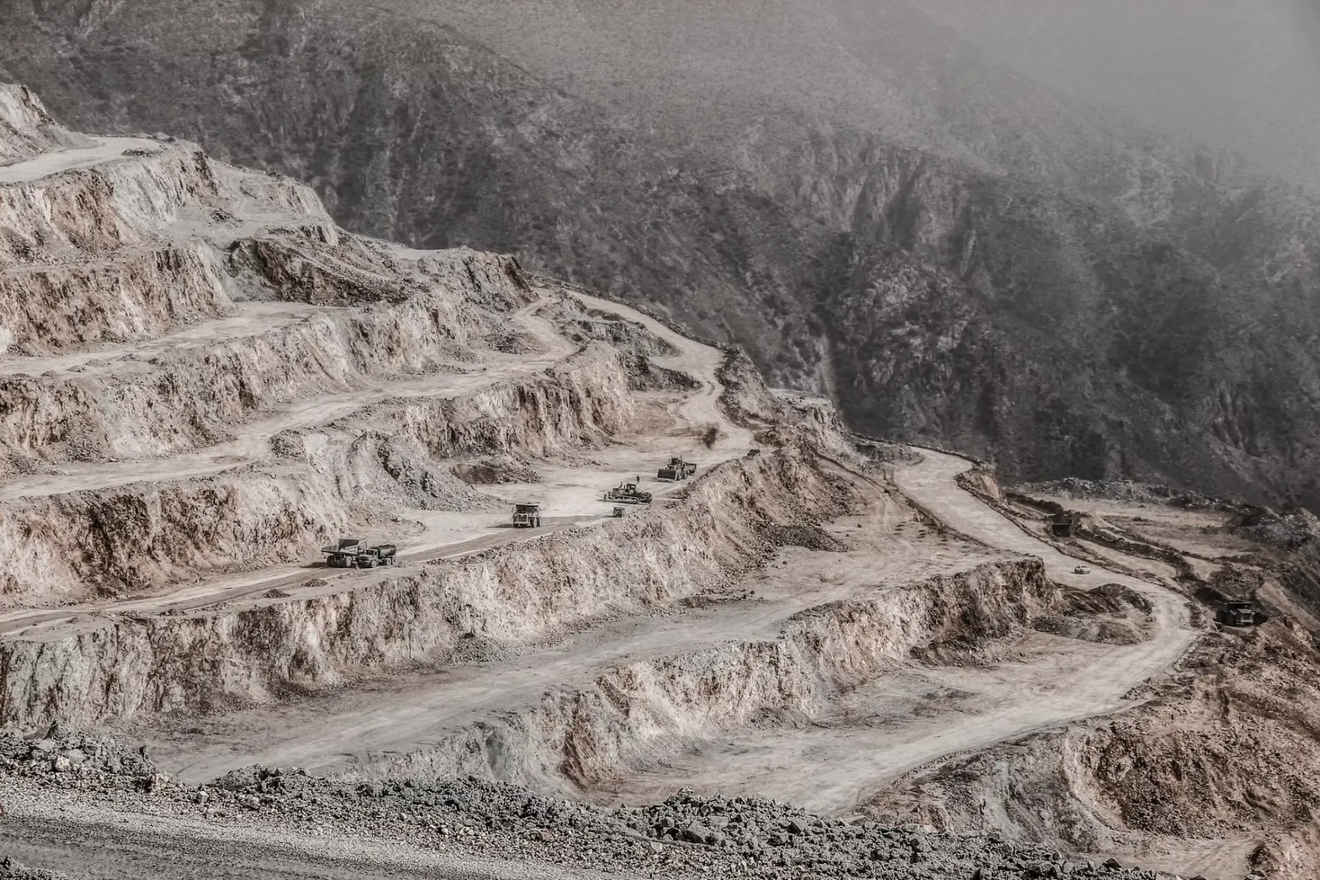 Open-pit copper mine with terraced benches and haul trucks